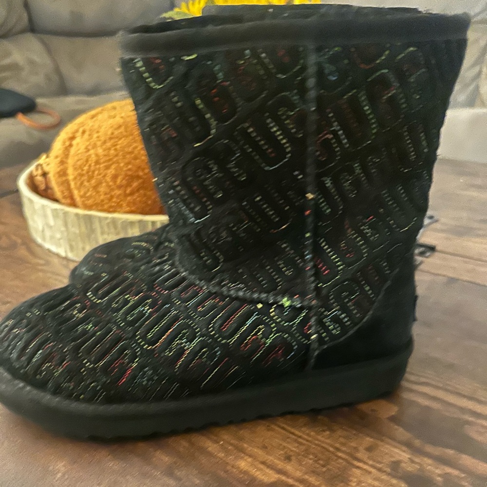 This is a pair of UGG Kids' Classic II Graphic Stitch boots in black suede